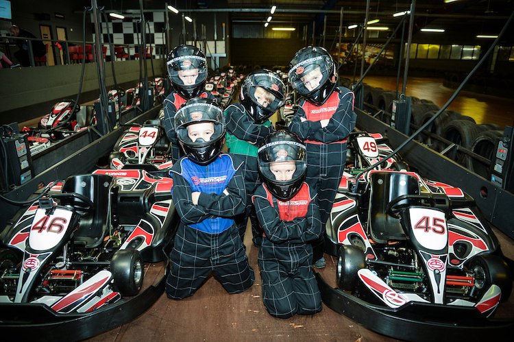 A group of children wit helmets on getting ready to Go Kart at TeamSport