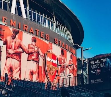 A family on a tour looking at the front of the outside of Arsenal stadium