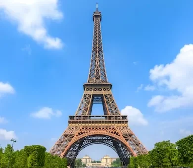 A luxury family standing on a viewing platform looking out over the panoramic skyline of Paris from the Eiffel Tower.