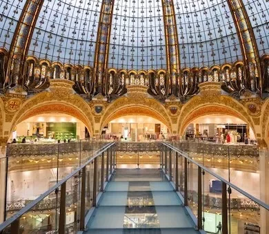 The magnificent historic stained glass dome and architecture of Galeries Lafayette with the exclusive glasswalk bridge in the center.