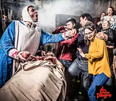 Live actors performing a theatrical historical scene at the London Dungeon attraction.