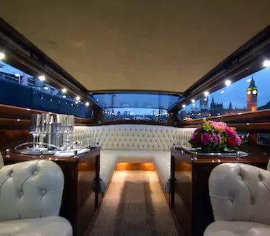 Luxury private river boat interior with a view of London parliament through the window.