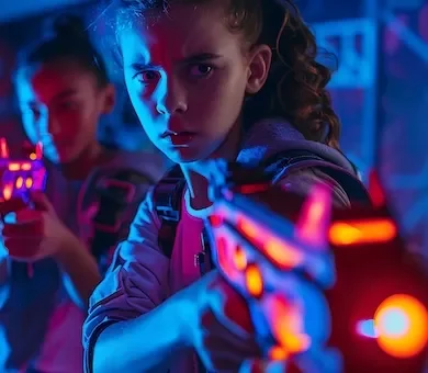 Children wearing glowing laser vests engaged in a private, high-tech laser tag experience in Paris.