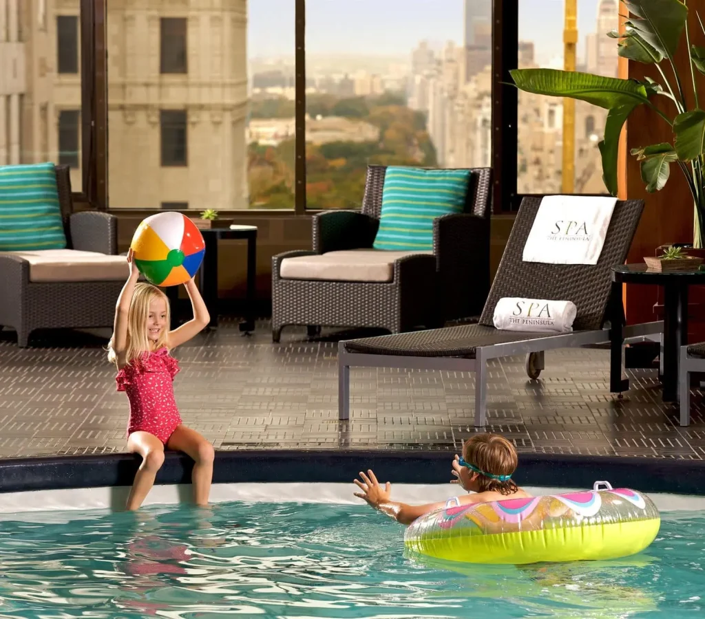 Children playing in the swimming pool at The Peninsula New York, part of VIP Trips for Kids hotel collection